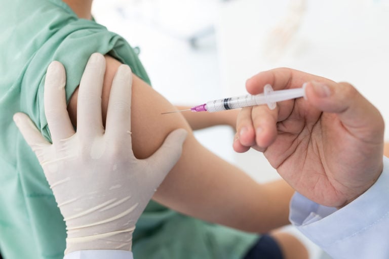 护士在儿童右臂注射疫苗。